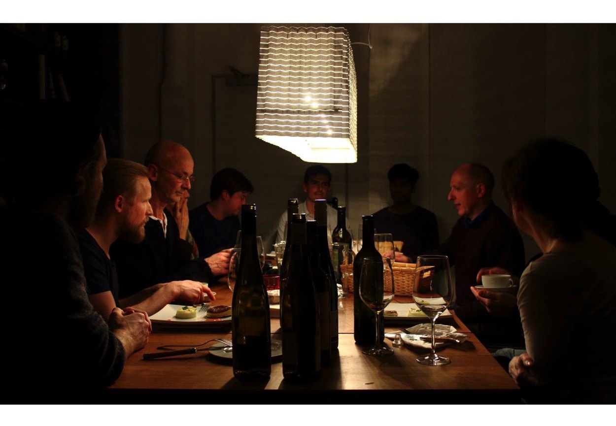 Guests at the long table under a hanging lamp